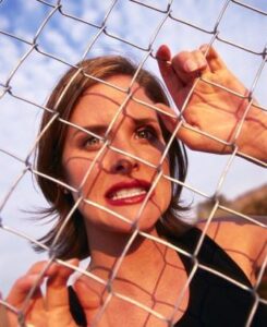 Woman Confined Behind a Chain-Link Fence
