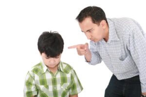 A father is threatening his little boy with a finger